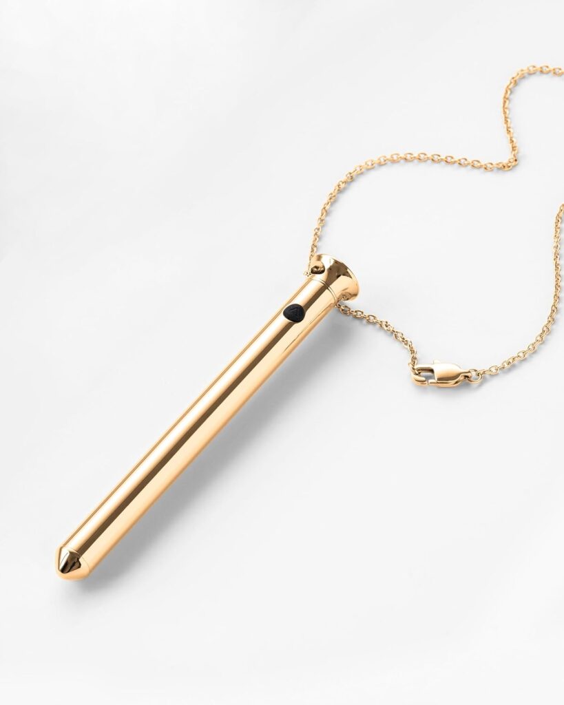 Gold necklace vibrator with necklace chain against a white background.
