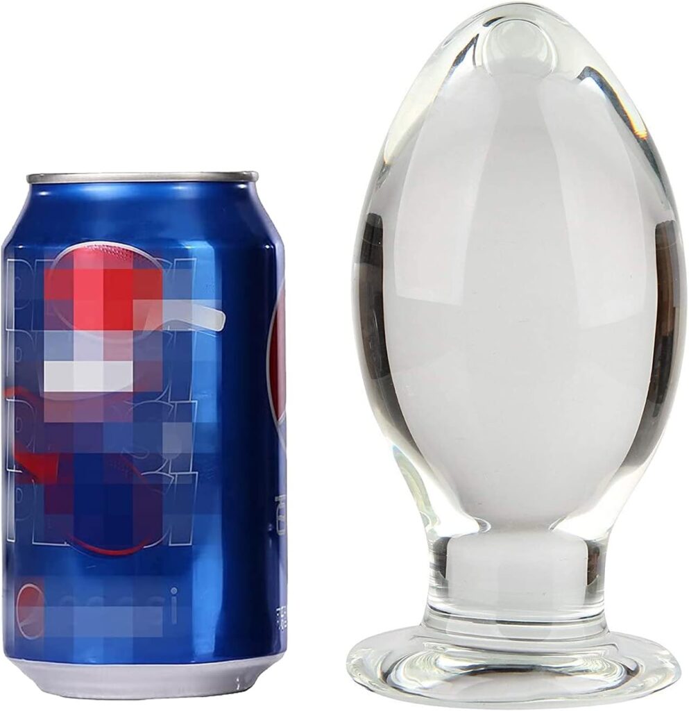 Large clear glass butt plug next to a can of Pepsi (TM) soda for size comparison.