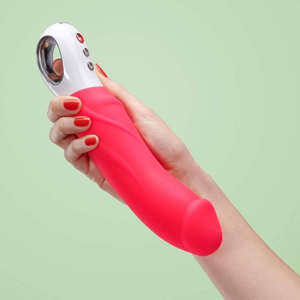 pink vibrating dildo held in a human hand